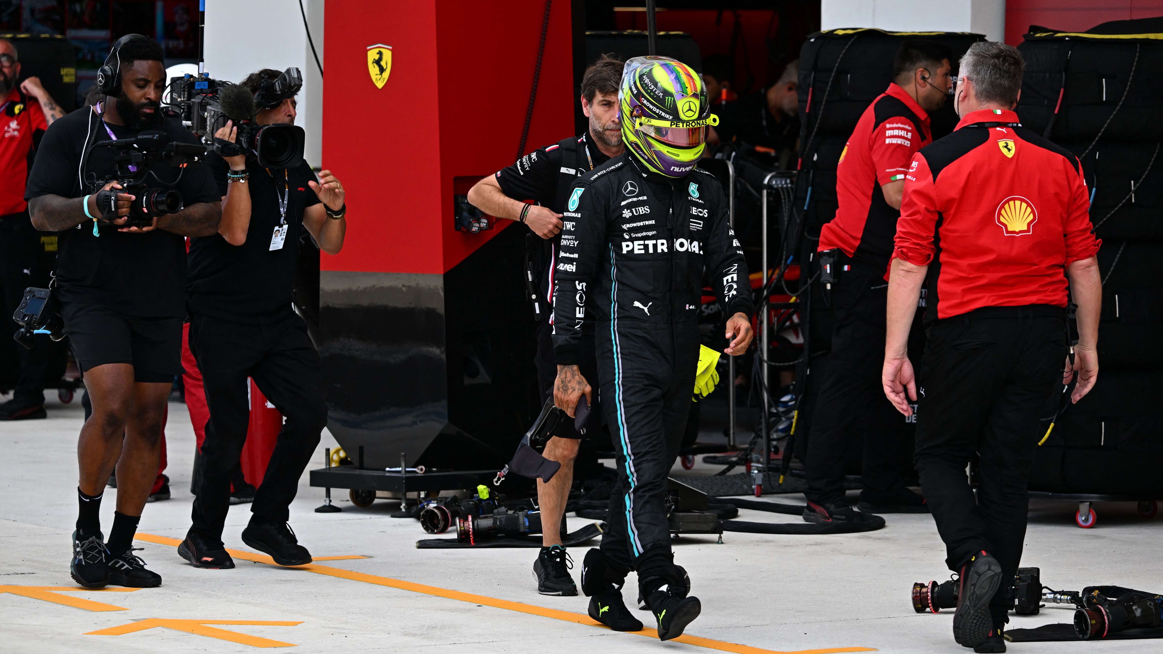 Mercedes' British driver Lewis Hamilton walk to a weigh in after the qualifying session for the